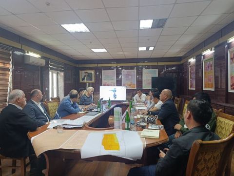 Participants at a meeting table with maps