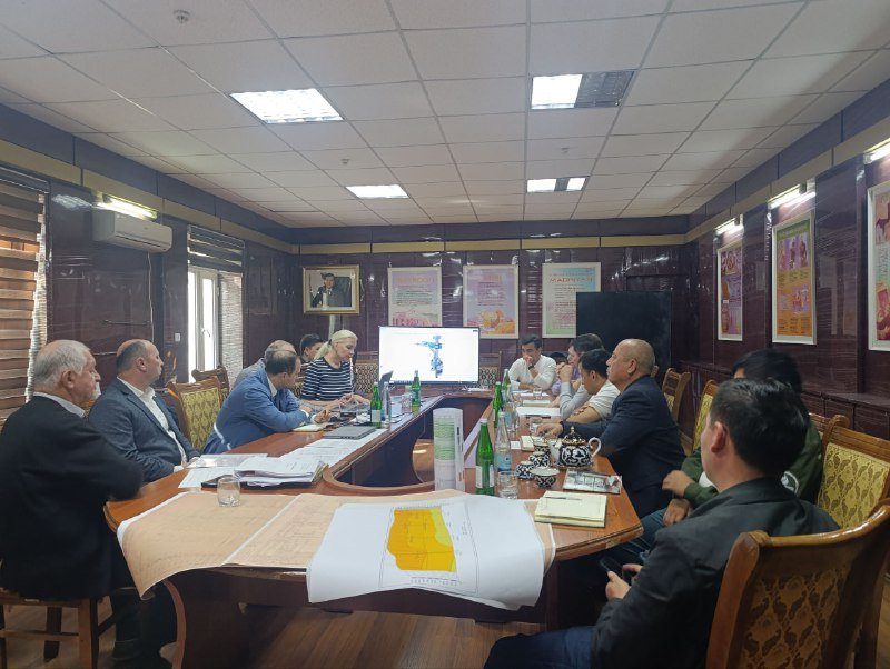 Participants at a meeting table with maps